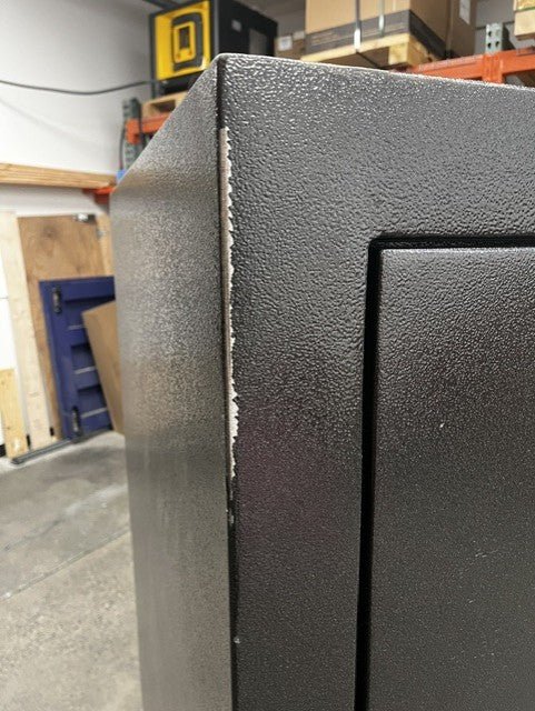 View of the left edge of the safe where the paint is chip. 