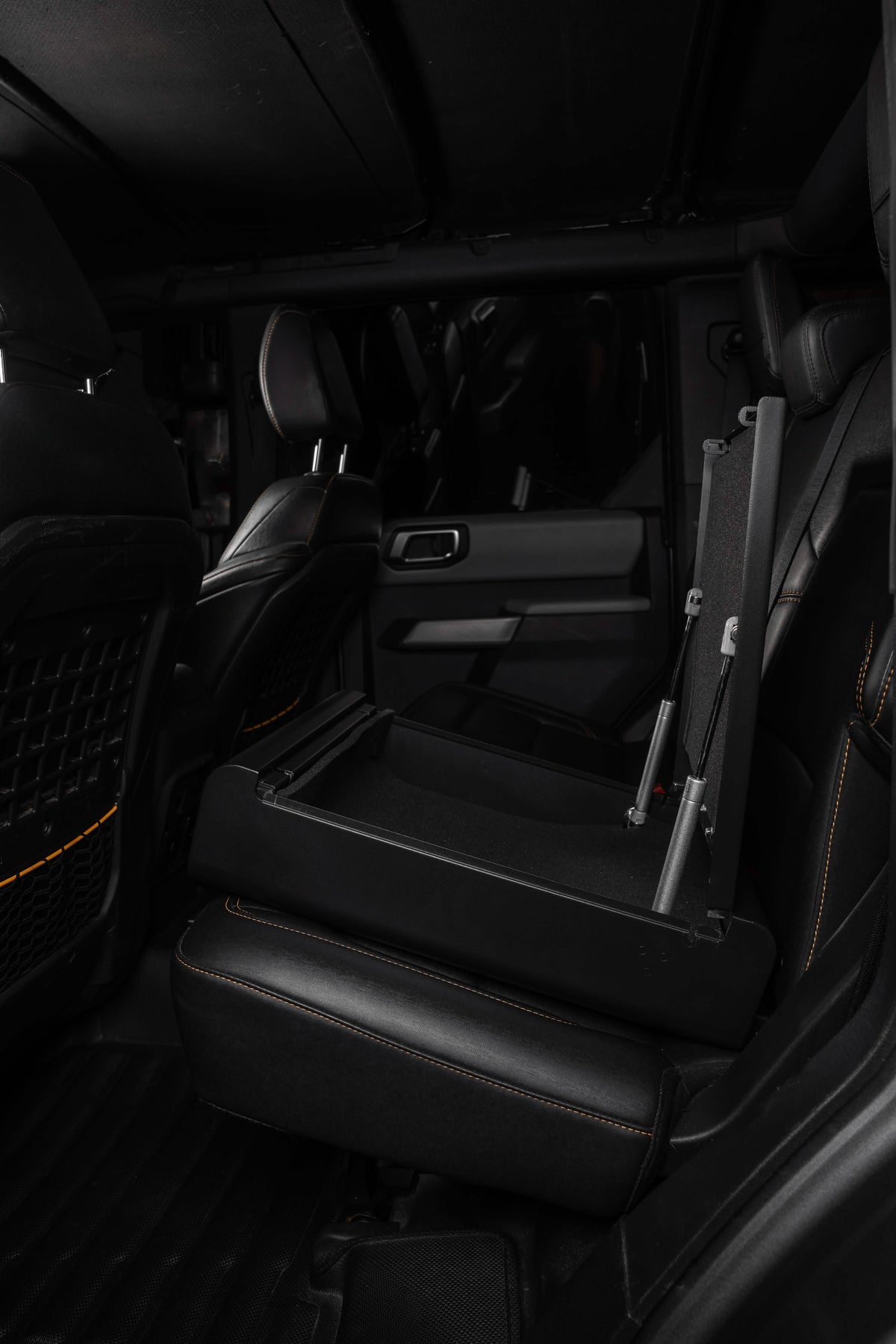 Dark interior of a vehicle with folded seat and open door