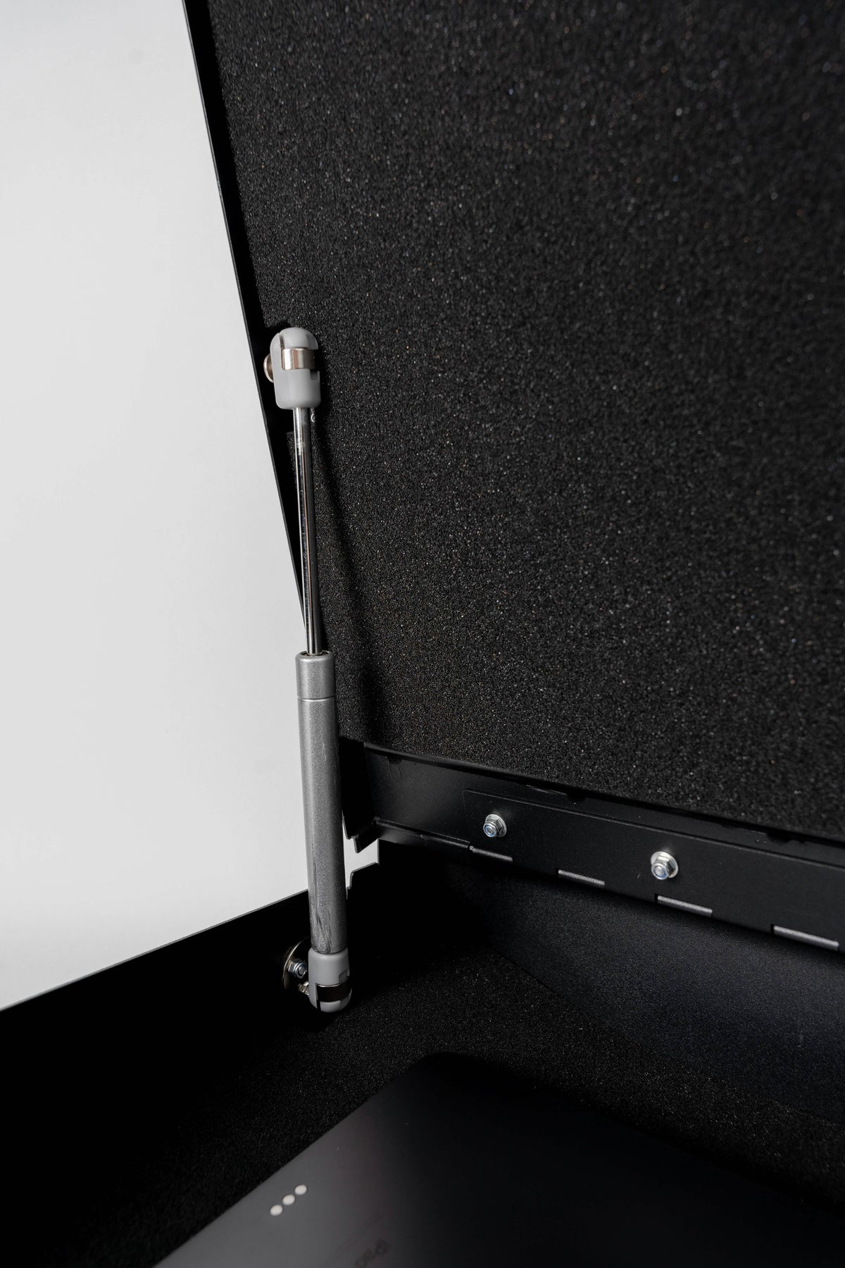 Close-up of a metal strut attached to a black panel on a white background