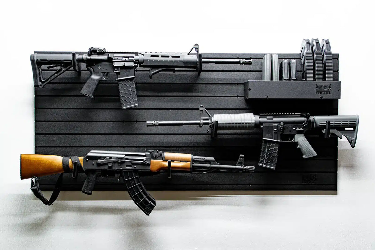 Three different types of rifles displayed on a black slat wall