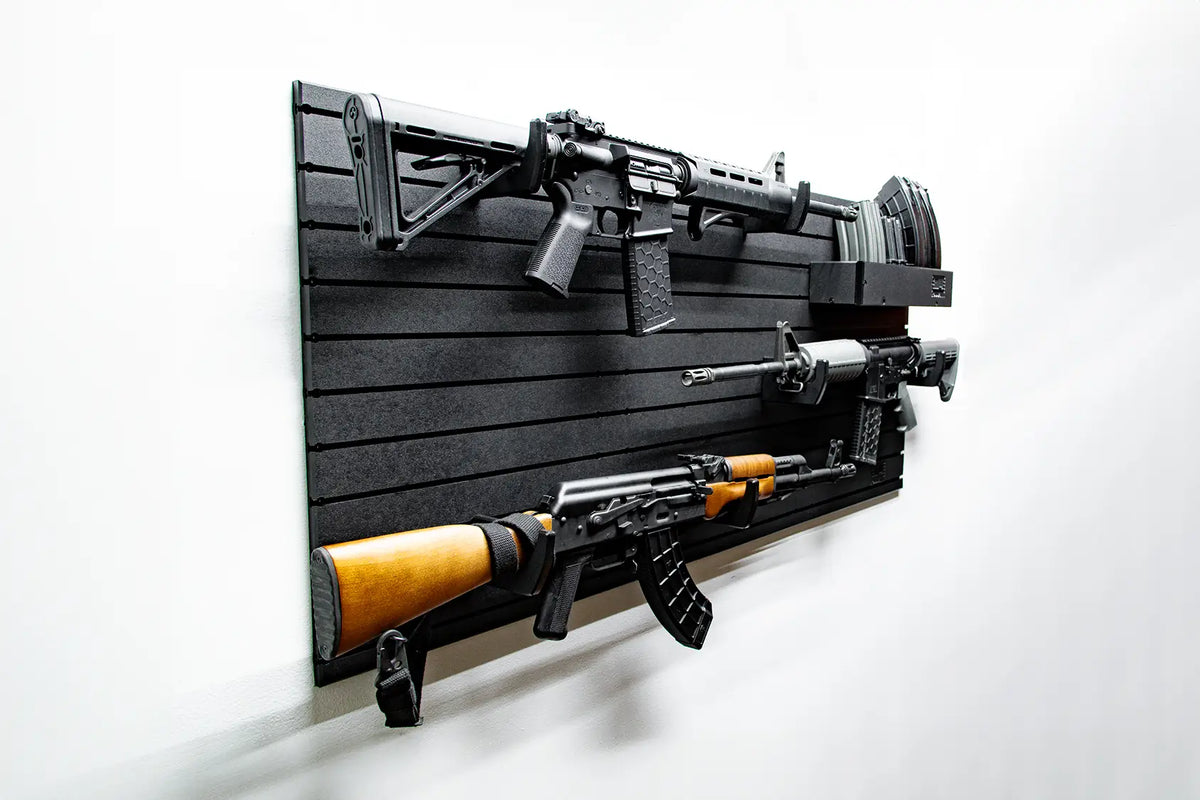 Wall-mounted gun display with two rifles on a black slat wall.
