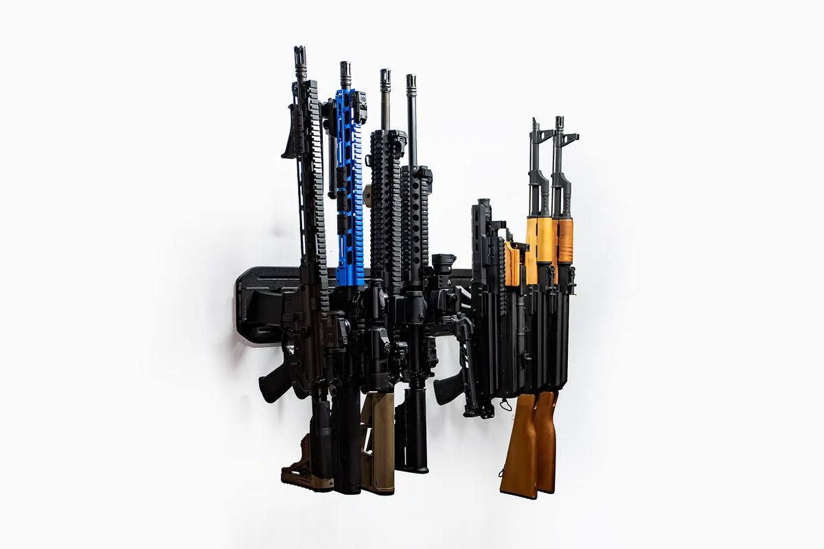 Wall-mounted gun rack holding various firearms on a white background