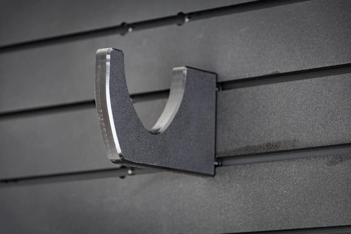 Metal bracket attached to a gray slat wall