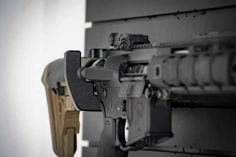 Close-up of a rifle with a scope on a plain background