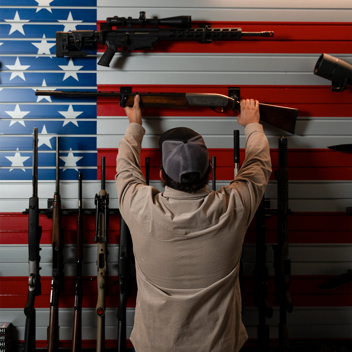 Person holding a rifle against an American flag background