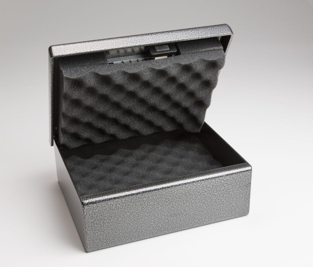 Fort Knox Original Handgun Safe Pistol Box PB1 in silver hammertone finish with the top lid fully open and hinged back, showing the interior compartment fully lined with black egg-crate acoustic foam padding on both the lid and the body base to protect a stored handgun from scratches