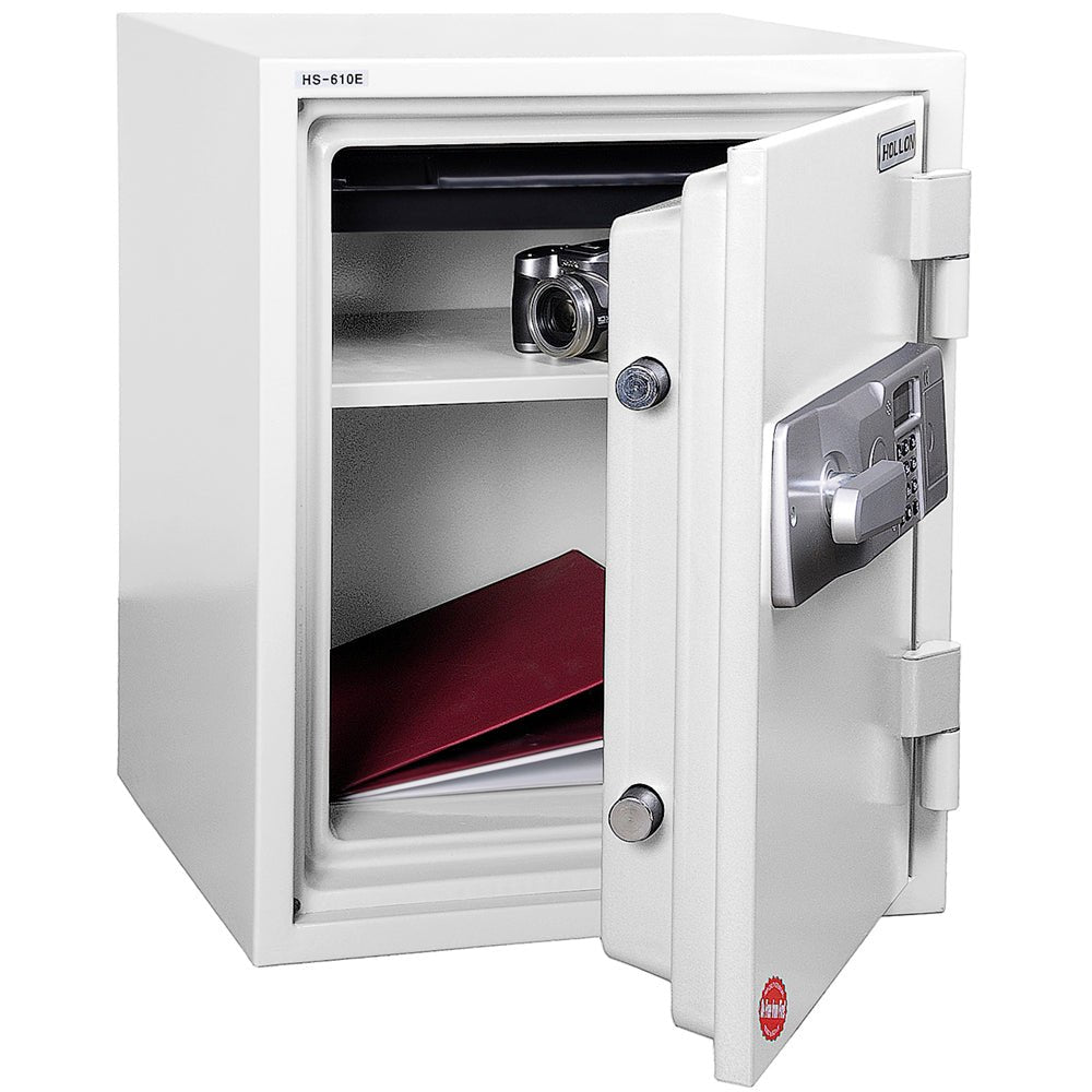 Hollon HS-610E fireproof home and office safe in white with door fully open showing the interior compartment with one adjustable black shelf holding a compact camera, a red binder and documents stored below on the safe floor, pre-drilled bottom anchor hole for floor mounting, two chrome active square locking bolts on the door edge, and Hollon fire test 'PASSED' certification label on the inside of the door