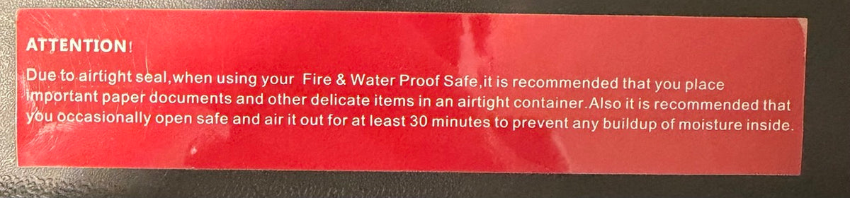 Red warning label on a metal surface with text about fire and water proof safe.