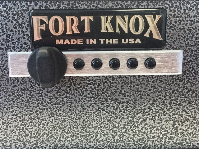 Close-up detail of the Fort Knox PB1 pistol box control face showing the black "FORT KNOX MADE IN THE USA" nameplate, the polished aluminum lock plate, the Simplex five-button mechanical pushbutton lock, and the black turn knob against the silver hammertone finish