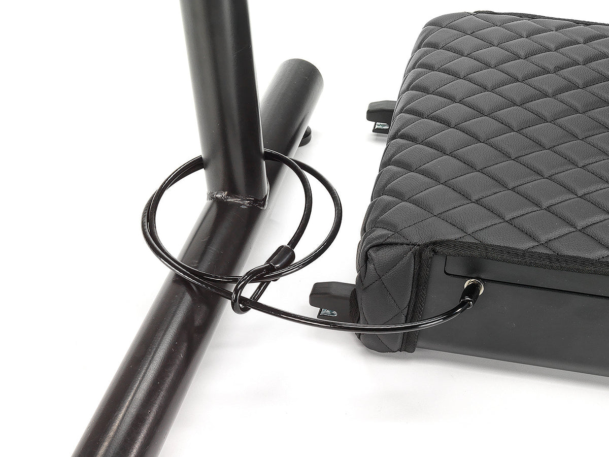 Black quilted bag with a strap attached to a black metal rod on a white background