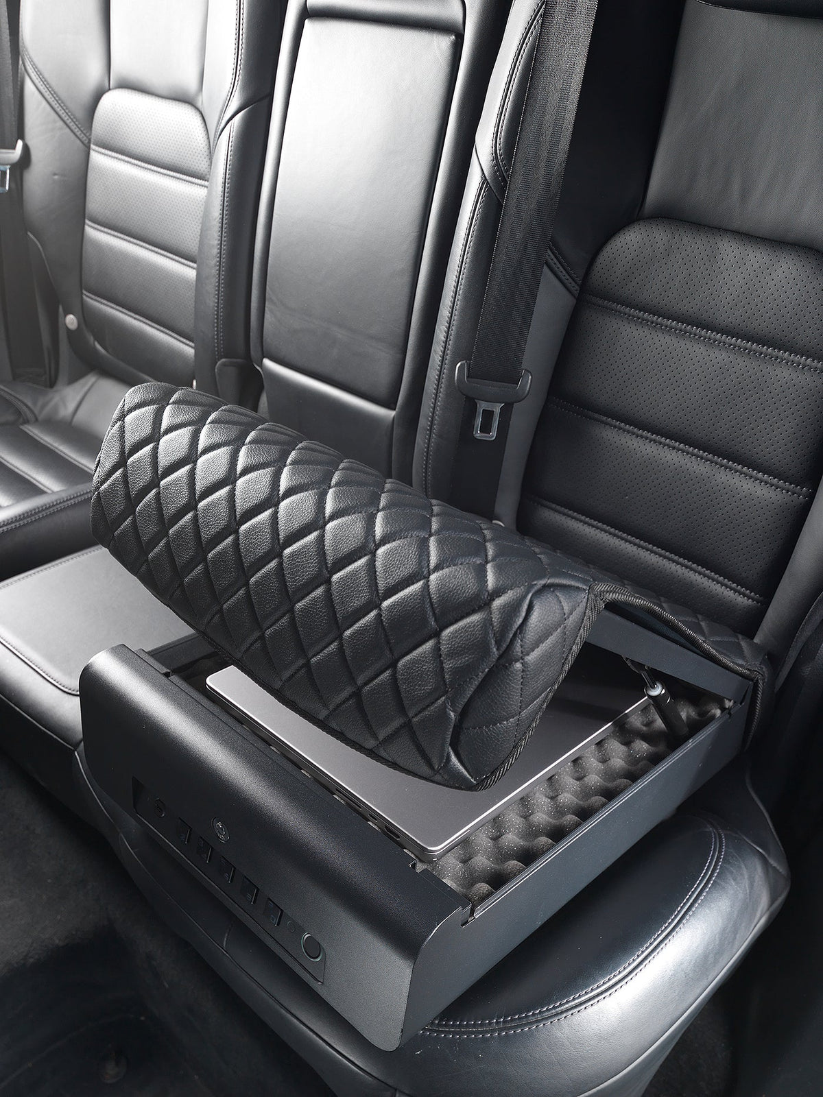 Black quilted car seat cover on a car seat with visible brand name.