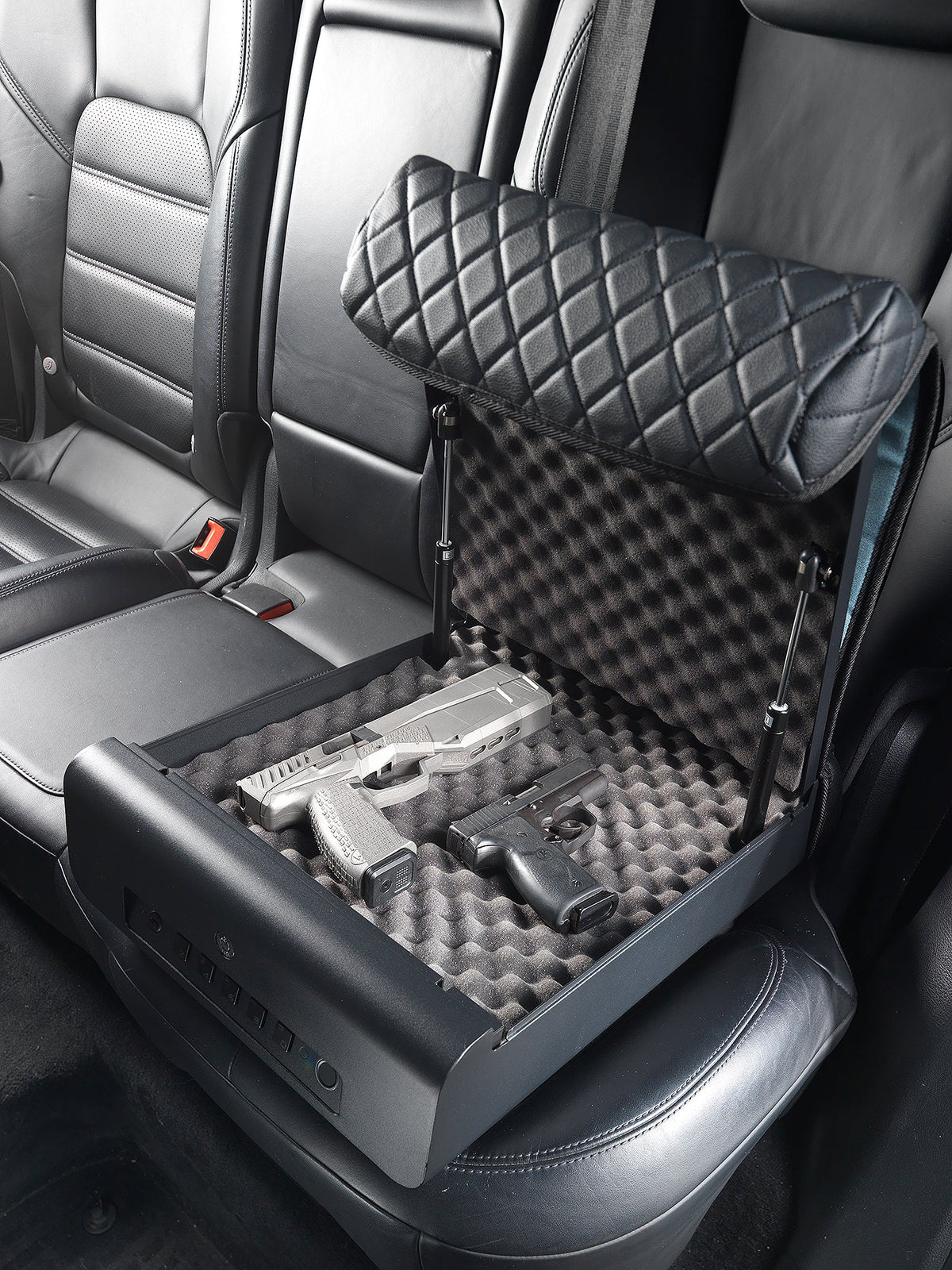 Car seat with a pet seat cover and cushion, showing a gun on the floor.