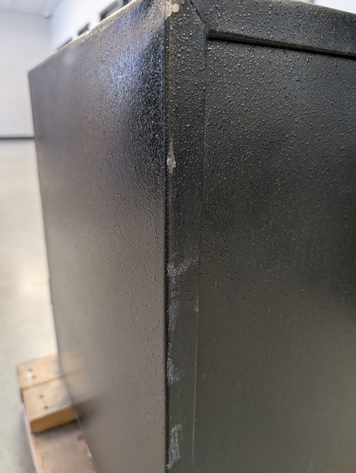 Close-up of the back of the safe where the edge is scratch. 