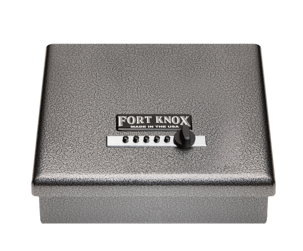 Fort Knox Original Handgun Safe Pistol Box PB1 shown from a top-down front angle in silver hammertone finish with a Simplex 5-button mechanical pushbutton lock and turn knob on the top-opening lid, "FORT KNOX MADE IN THE USA" nameplate, top-hinged clamshell pistol-box form factor for tabletop or drawer storage