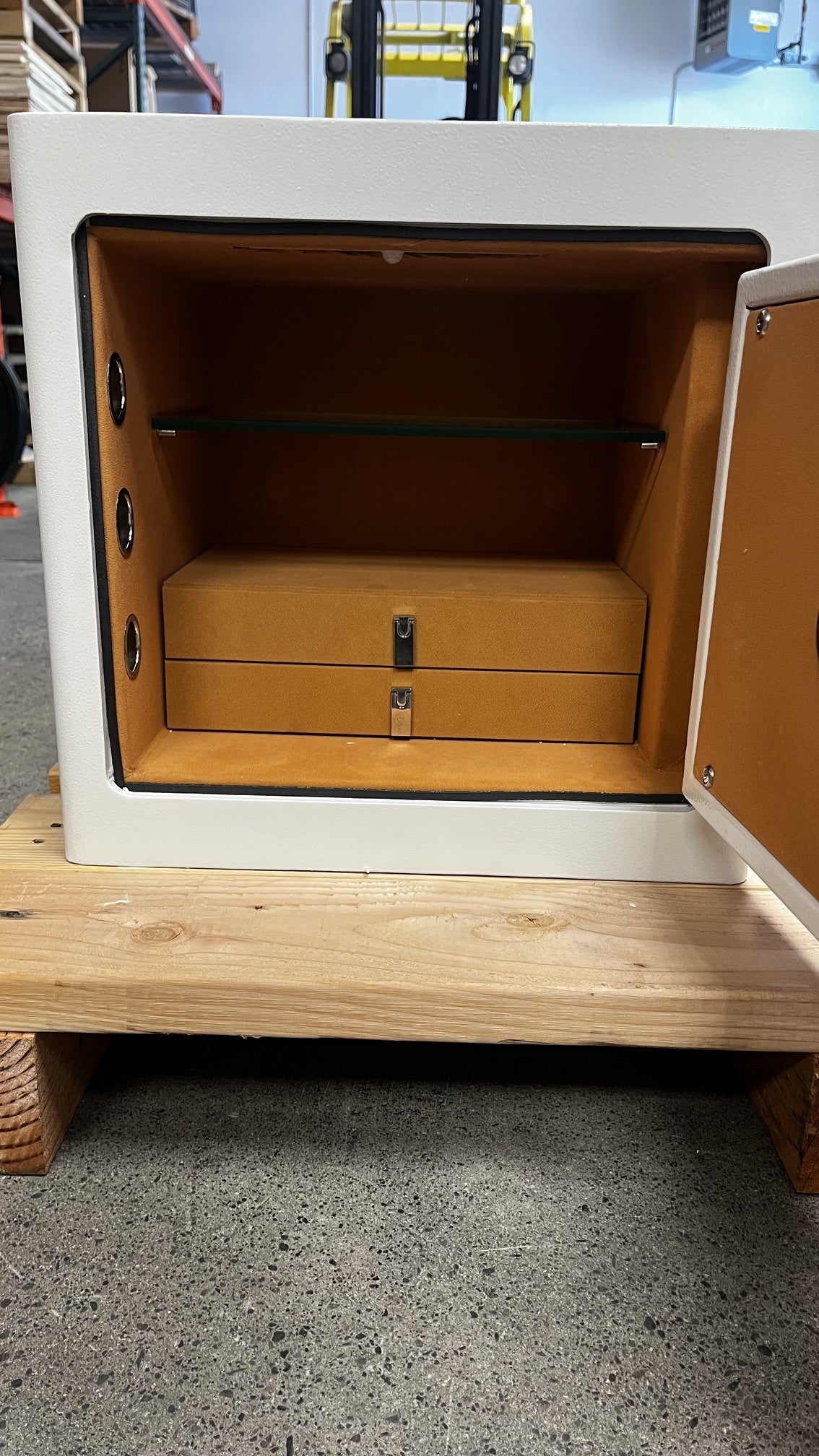 View of the inside of the safe. The safe comes with one glass shelf that is adjustable. It has two jewelry drawers. 
