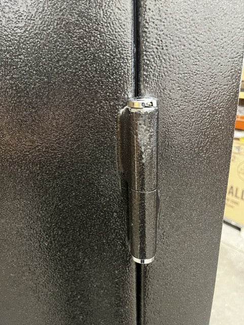 View of the top right hinge. The lid on top of the hinge has a crack and scratches. 