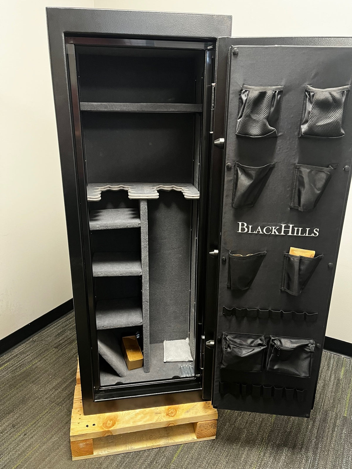 Front view of the safe with the door open. The door has pistol organizers 