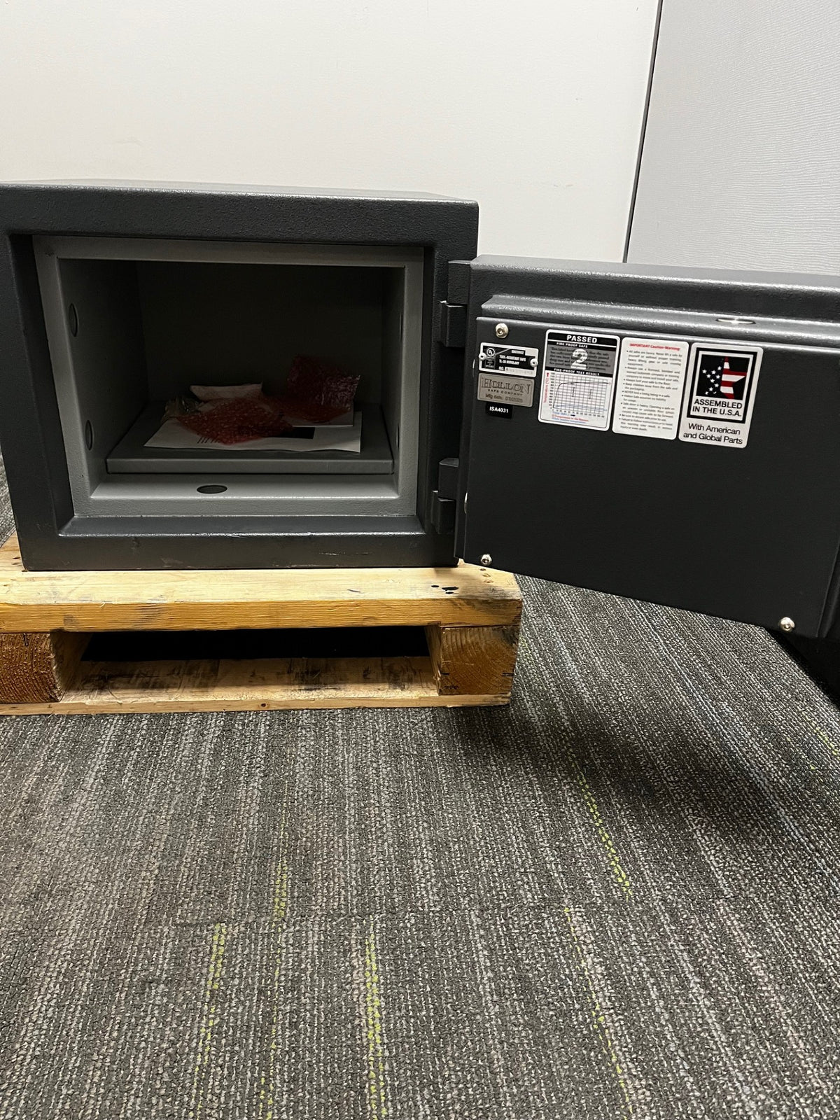Front view of the safe with the door open. It has one adjustable shelf. 